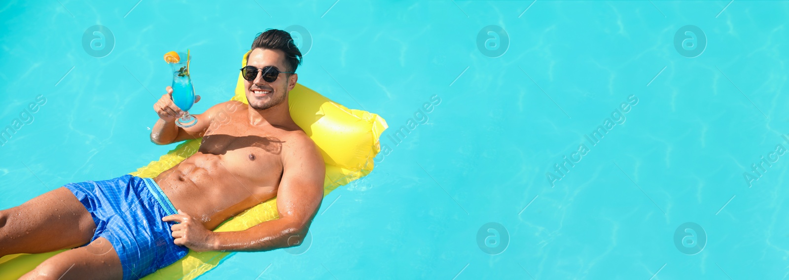 Image of Young man with cocktail and inflatable mattress in swimming pool on sunny day. Banner design