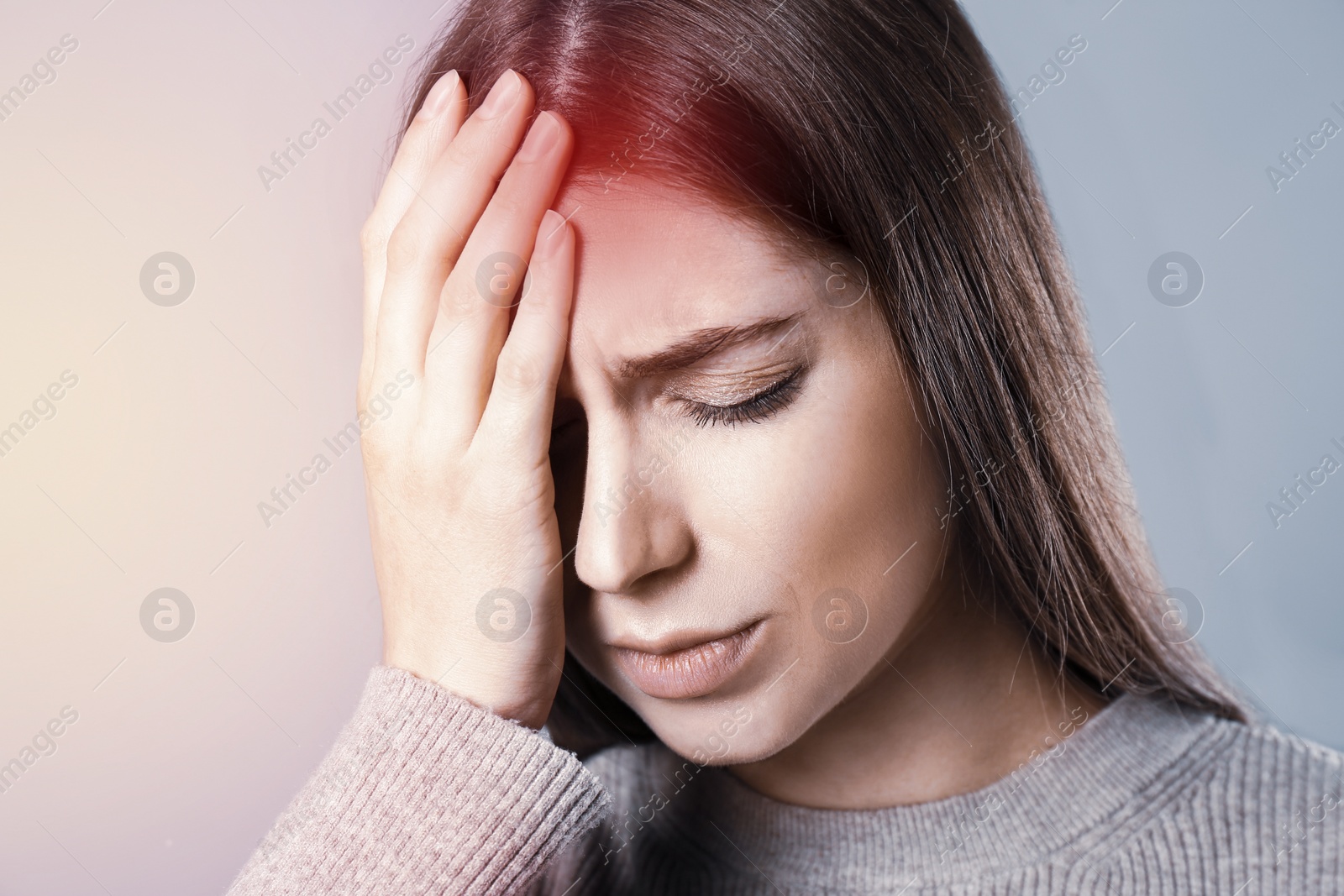 Image of Young woman suffering from migraine on grey background