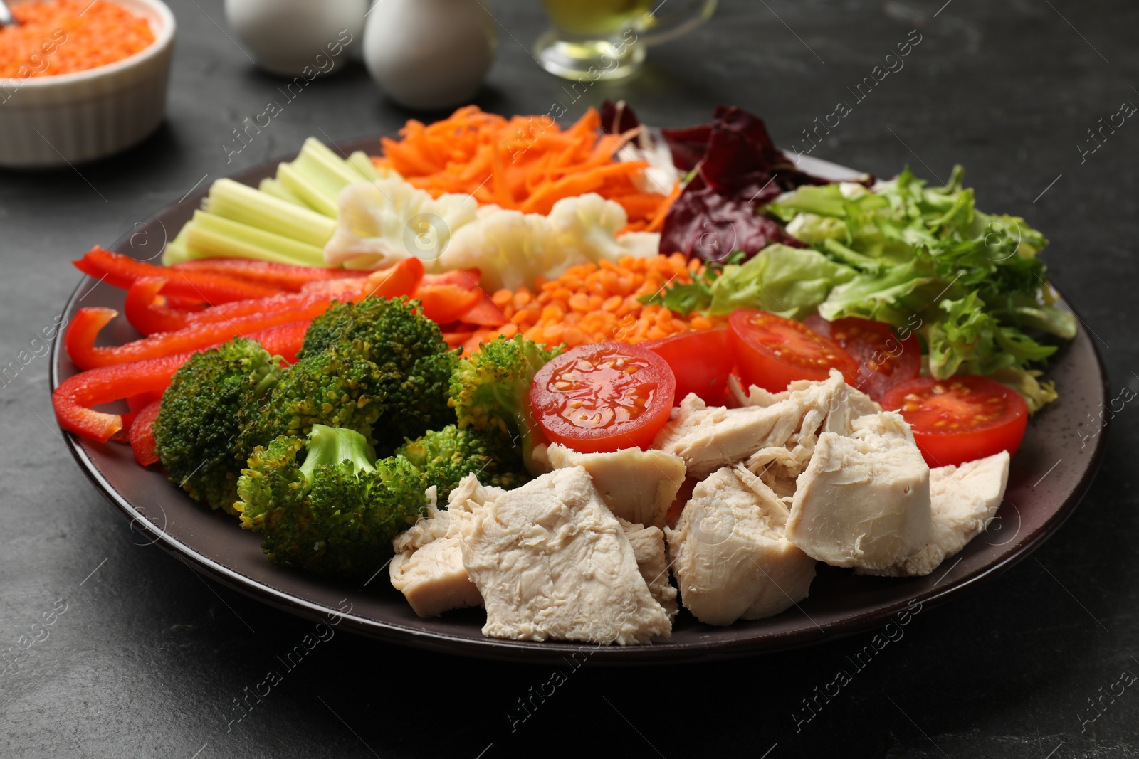 Photo of Balanced diet and healthy foods. Plate with different delicious products on black table, closeup