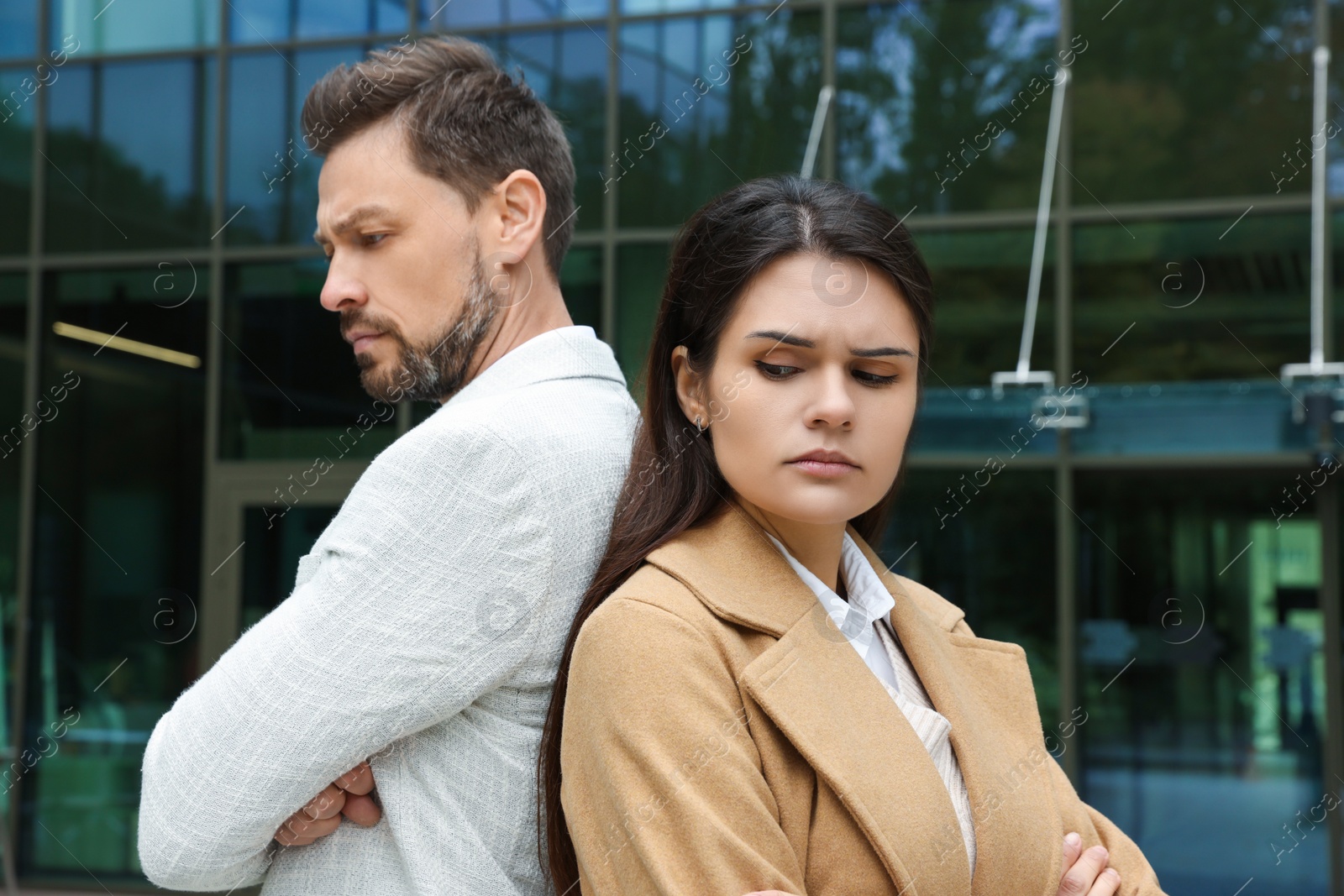 Photo of Upset arguing couple near building outdoors. Relationship problems