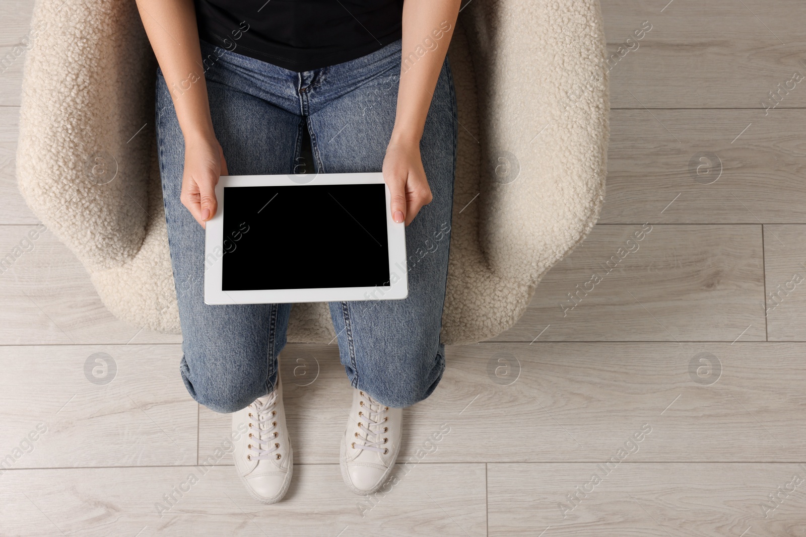 Photo of Woman working with tablet in armchair, top view. Space for text