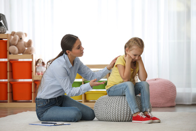 Child psychotherapist working with little girl in office