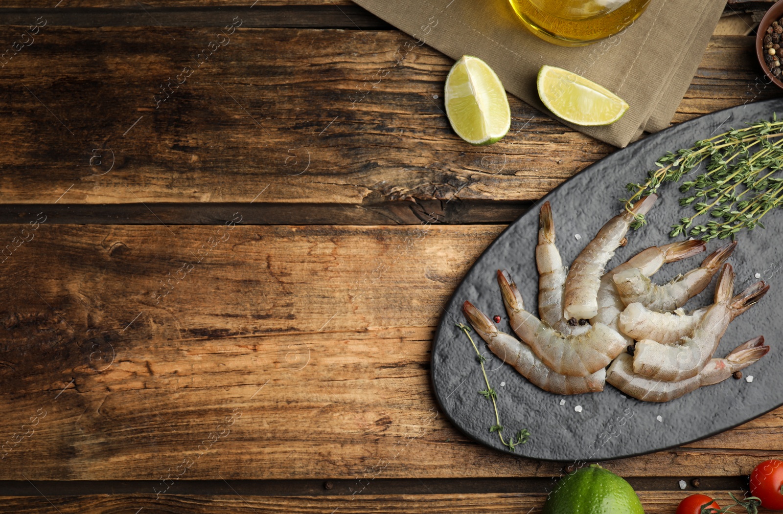 Photo of Flat lay composition with fresh raw shrimps on wooden table. Space for text