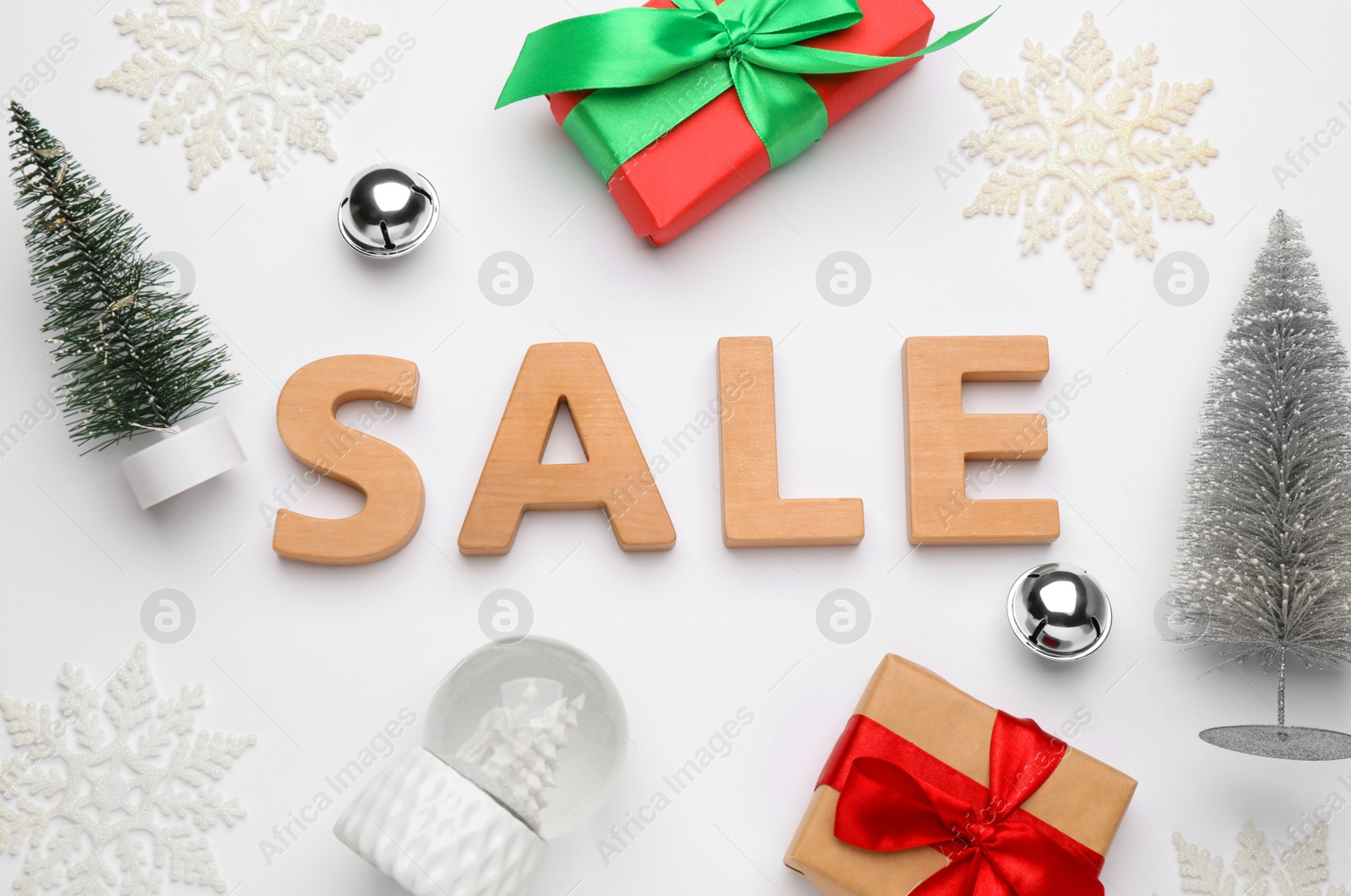 Photo of Word Sale of wooden letters, gift  boxes and  Christmas decor on white background, top view