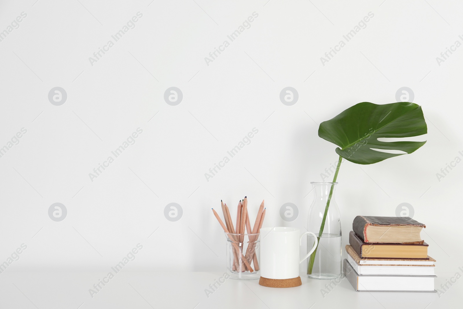 Photo of Comfortable workplace with white desk near wall at home