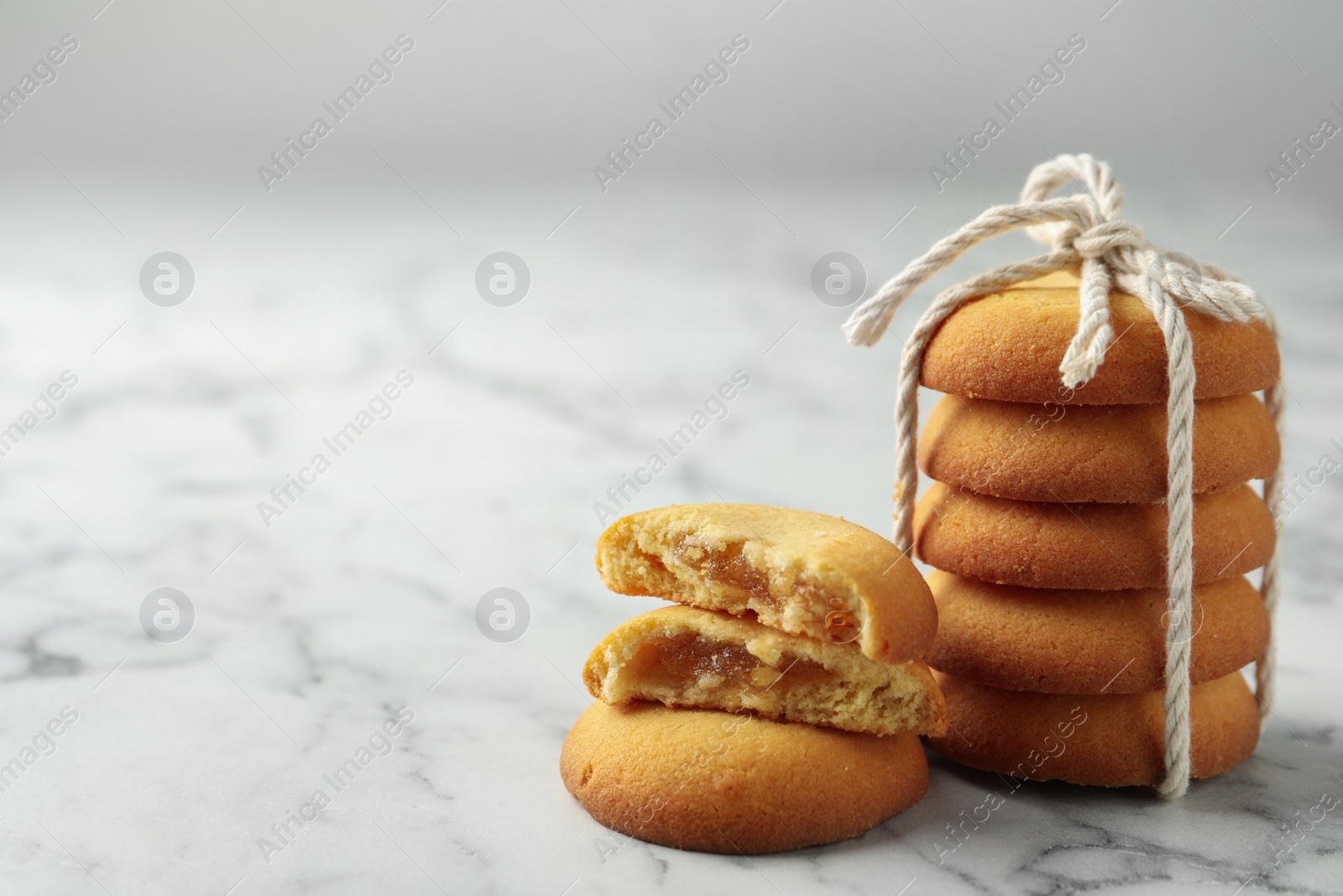 Photo of Tasty shortbread cookies on marble table, closeup. Space for text