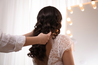 Stylist working with client in salon, making wedding hairstyle
