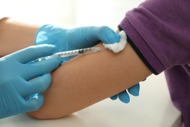 Photo of Doctor vaccinating little child in clinic, closeup