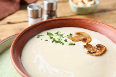 Photo of Delicious cream soup with mushrooms in bowl, closeup