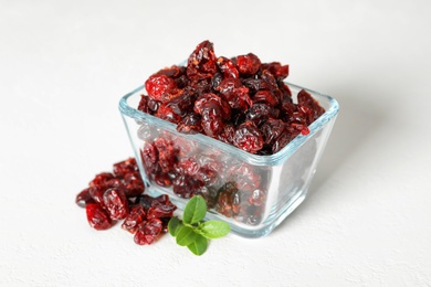 Photo of Tasty dried cranberries and leaves on white table
