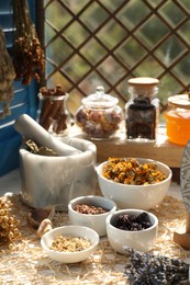 Photo of Many different dry herbs and flowers on table near window