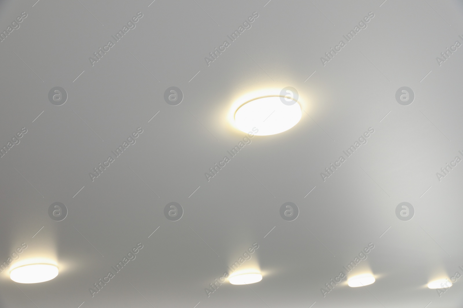 Photo of White ceiling with lamps indoors, below view