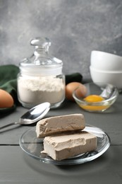 Compressed yeast, eggs and flour on grey wooden table