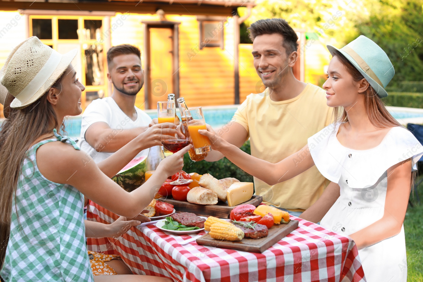 Photo of Happy friends with drinks having fun at barbecue party outdoors