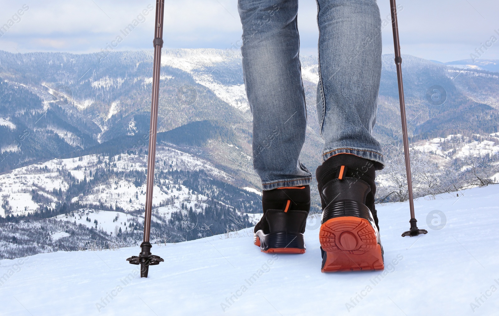 Image of Man with trekking poles in snowy mountains, closeup