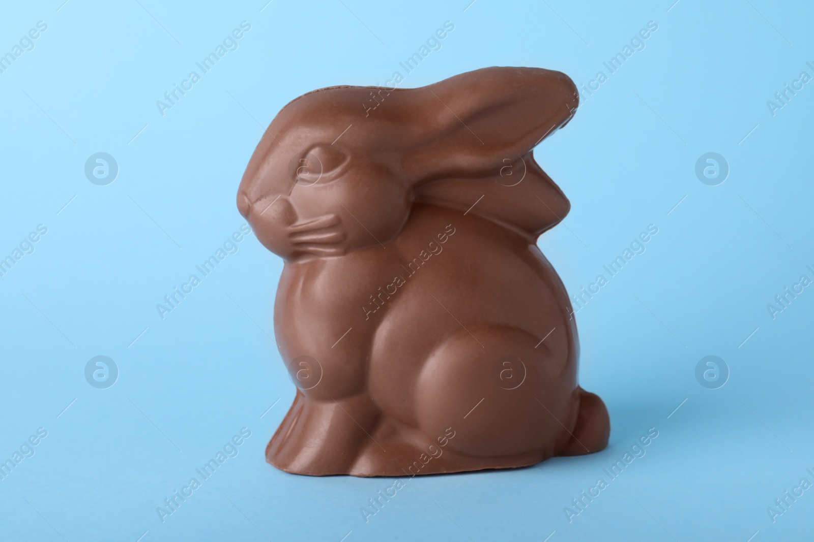 Photo of Chocolate bunny on light blue background. Easter celebration