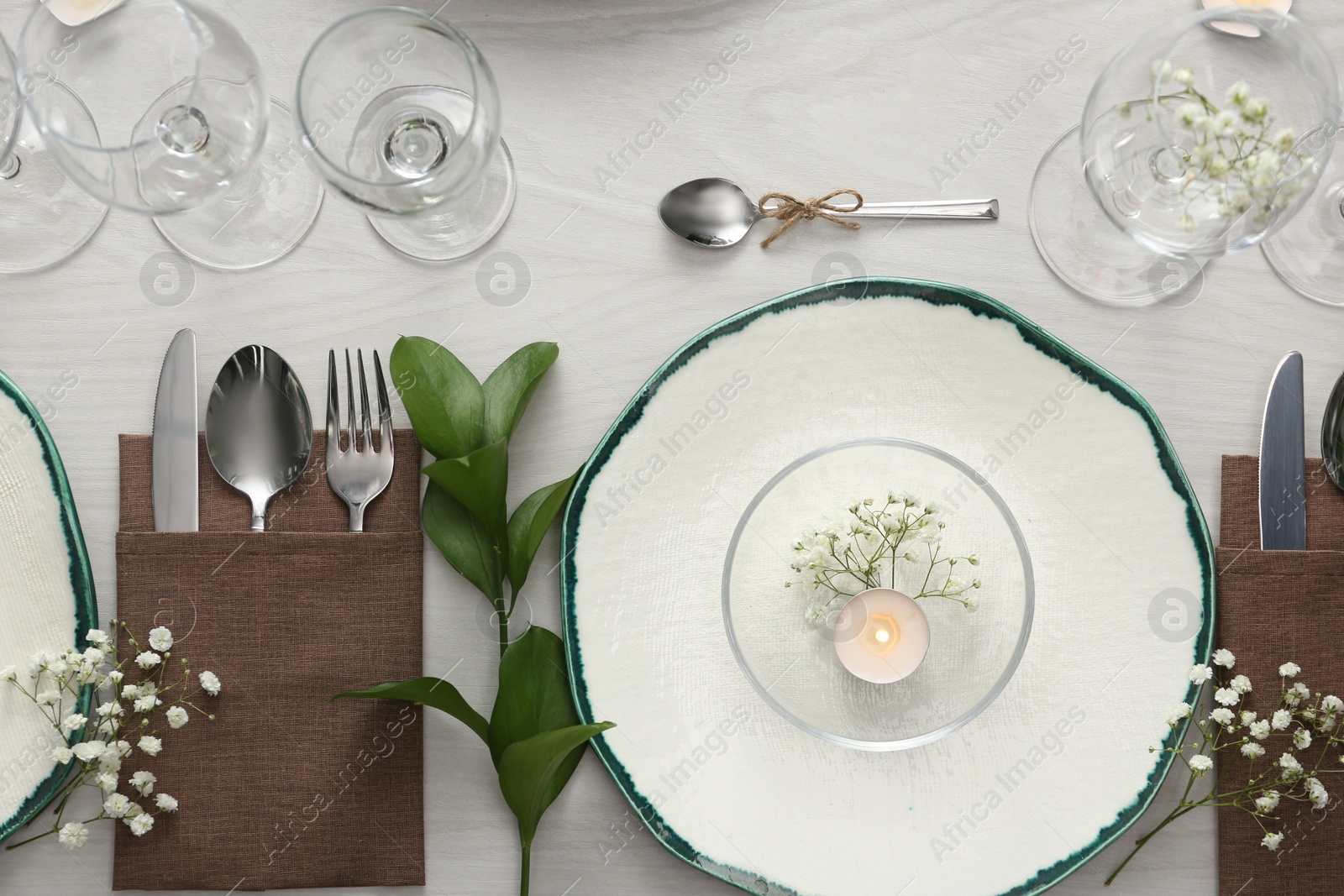 Photo of Elegant table setting with green plants on white wooden background, flat lay