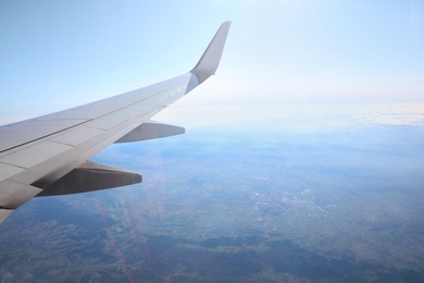 Image of Airplane flying in sky, view on wing. Air transportation