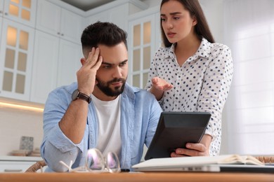 Young couple discussing family budget in kitchen