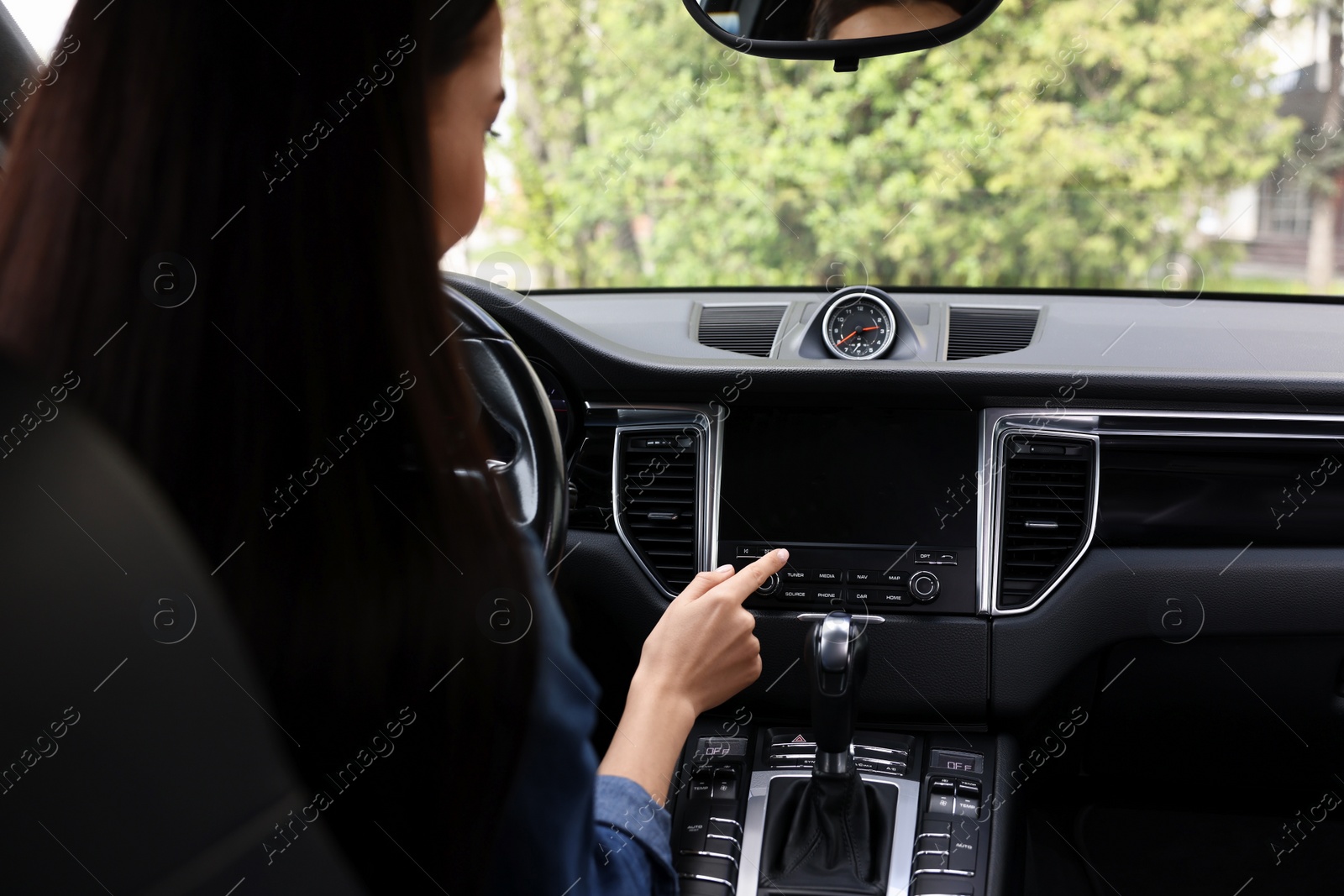 Photo of Woman using navigation system while driving her car, closeup