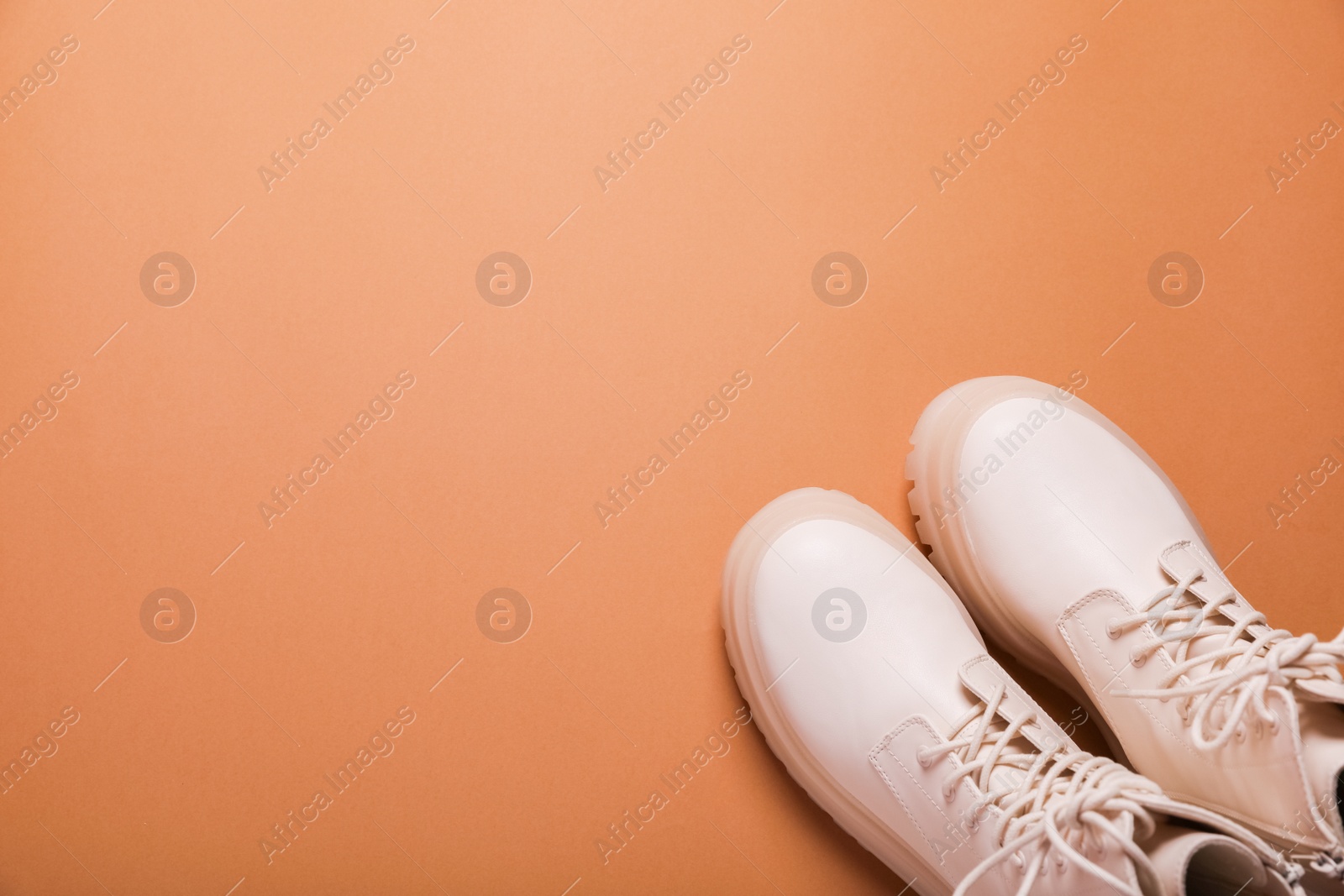 Photo of Pair of stylish leather shoes on light brown background, flat lay. Space for text