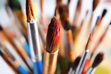 Different paint brushes on blurred background, closeup