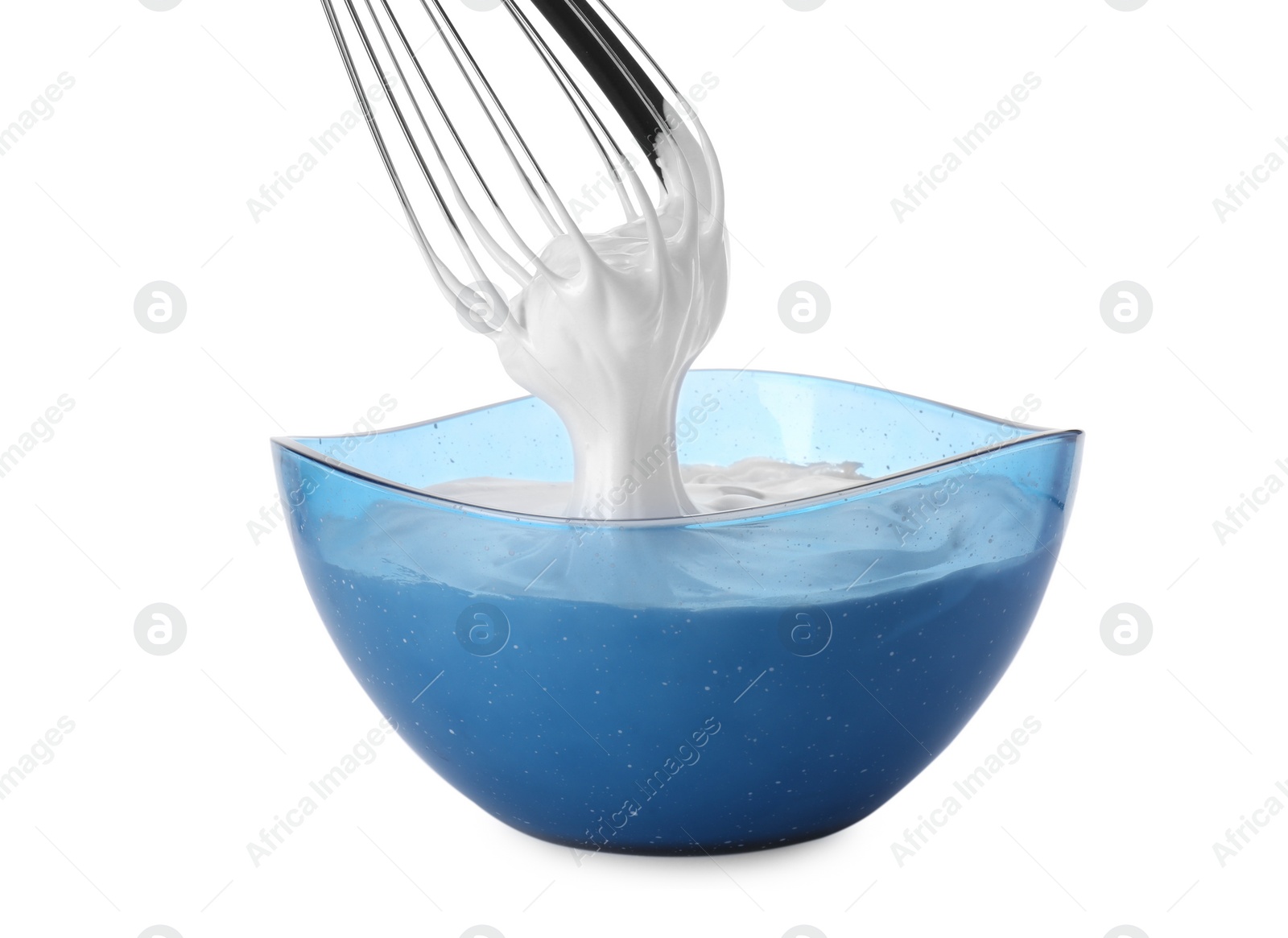 Photo of Whipped cream flowing from whisk into bowl isolated on white