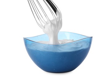 Photo of Whipped cream flowing from whisk into bowl isolated on white