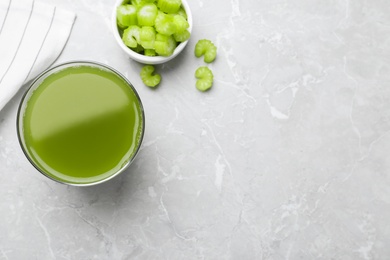 Photo of Glass of fresh celery juice on grey table, flat lay. Space for text