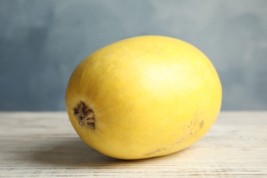 Ripe spaghetti squash on wooden table against color background