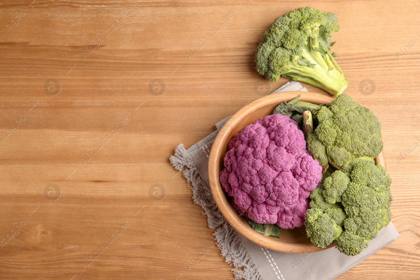 Photo of Plate with different cabbages on wooden table, top view. Healthy food