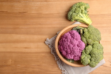 Photo of Plate with different cabbages on wooden table, top view. Healthy food