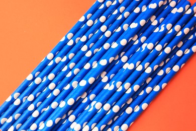 Many paper drinking straws on orange background, flat lay