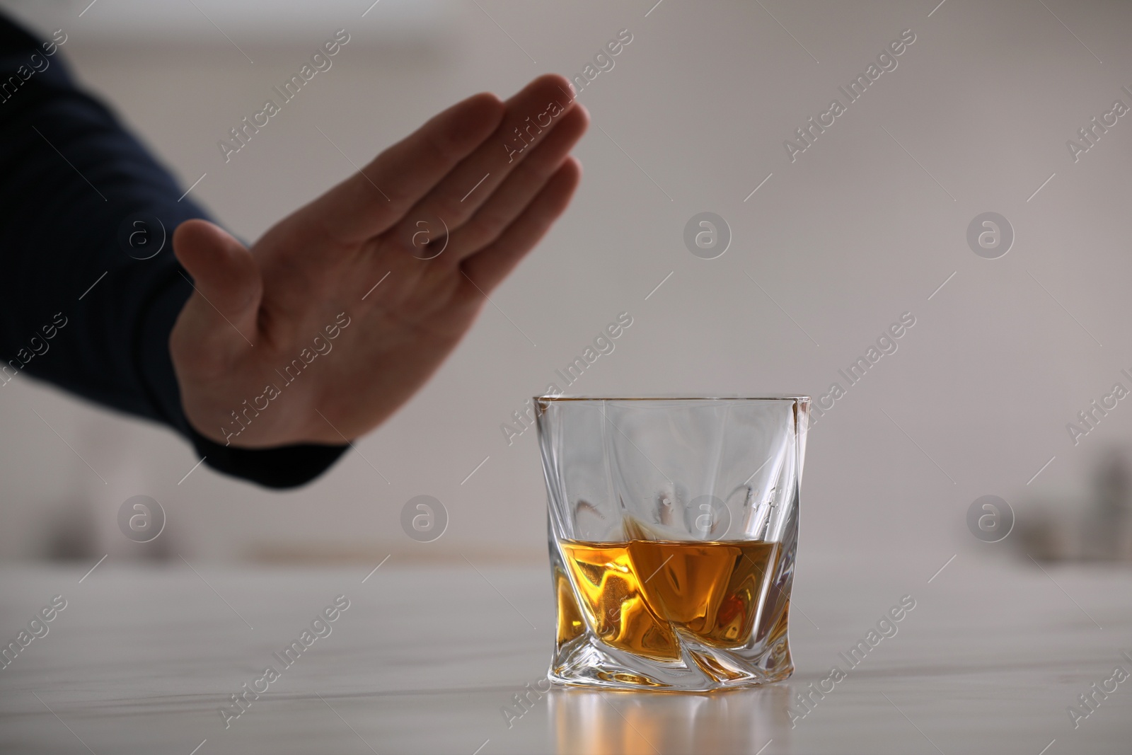 Photo of Man refusing to drink whiskey indoors, closeup. Alcohol addiction treatment