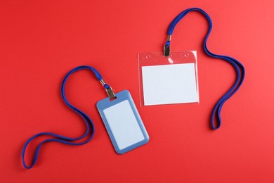 Photo of Blank badges on red background, flat lay. Mockup for design
