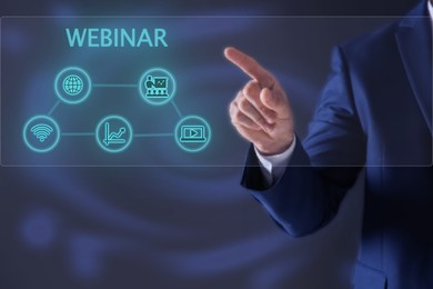 Image of Webinar. Businessman using virtual screen with icons on blue background, closeup