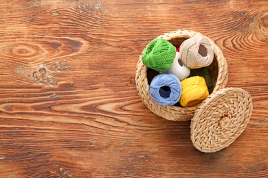 Small box with set of color threads on wooden background