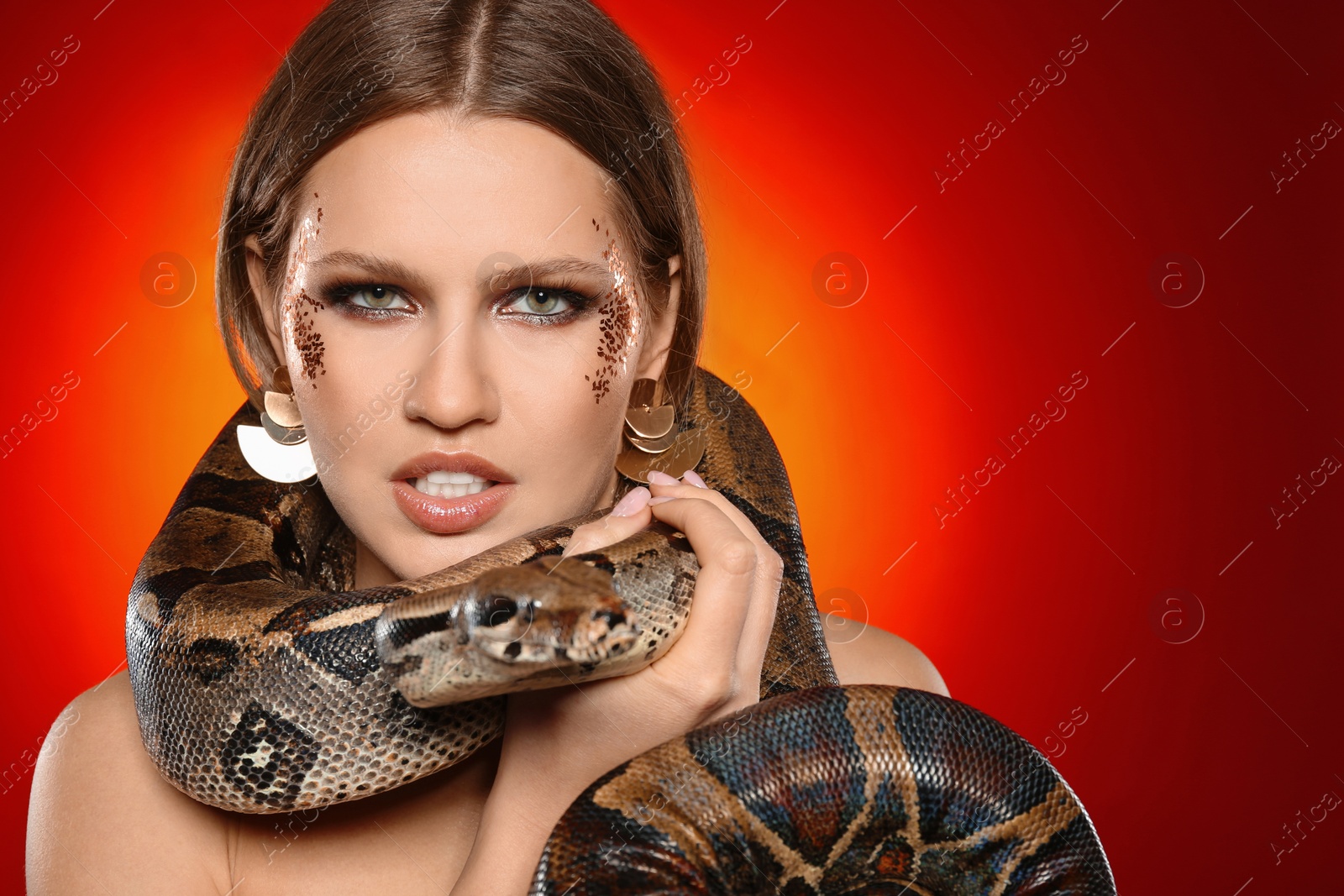 Photo of Beautiful woman with boa constrictor on bright colorful  background. Space for text