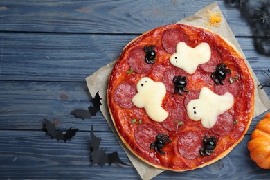 Cute Halloween pizza with ghosts and spiders served on blue wooden table, flat lay