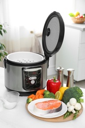 Modern multi cooker and products on kitchen table