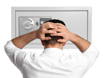 Financial security, keeping money. Thoughtful businessman in front of big steel safe on white background, back view