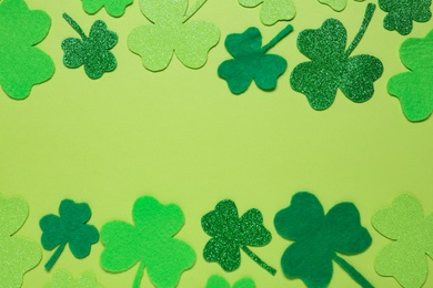 Photo of Flat lay composition with clover leaves on light green background, space for text. St. Patrick's Day celebration