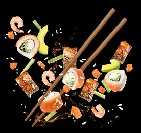 Different sushi rolls and ingredients on black background