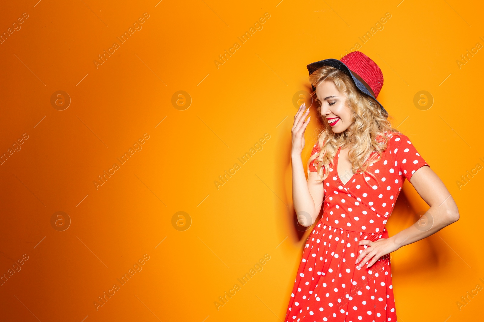 Photo of Stylish young woman with hat posing on color background