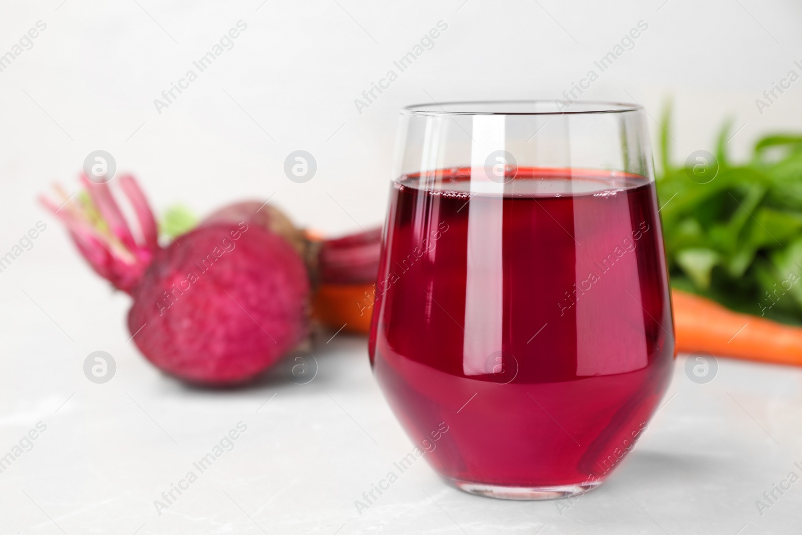 Photo of Glass with fresh beet juice on table