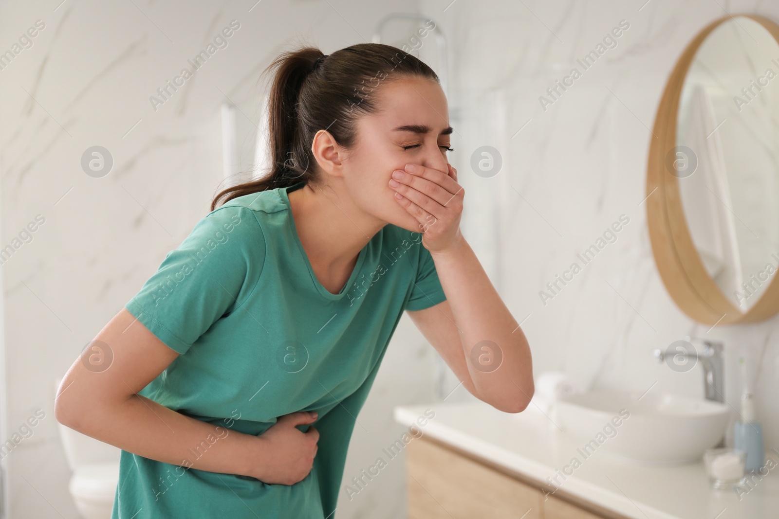 Photo of Young woman suffering from nausea in bathroom. Food poisoning