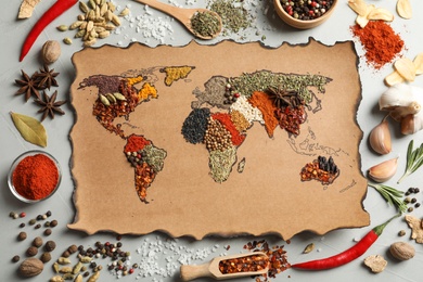 Photo of Paper with world map made of different aromatic spices on gray background, flat lay