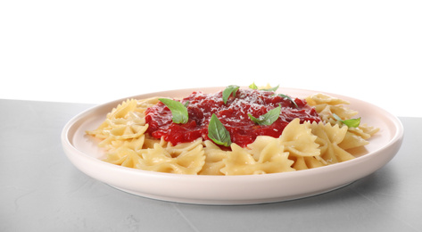 Tasty pasta with tomato sauce, basil and cheese on light grey table against white background