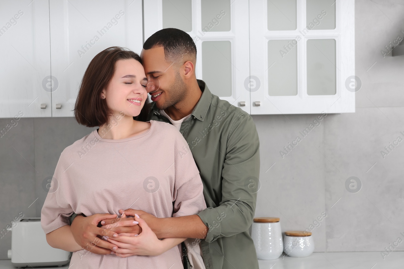 Photo of Dating agency. Lovely couple embracing in kitchen, space for text