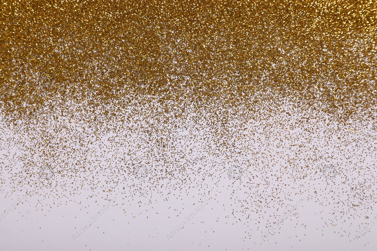 Photo of Shiny golden glitter on white background, top view